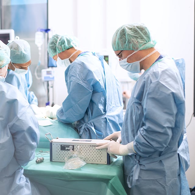 Fyra veterinärer iklädda skyddskläder i operationsrummet.