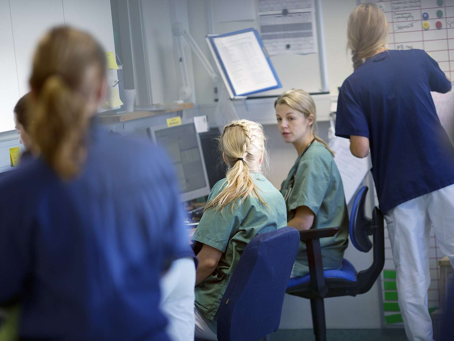 Veterinärer och sköterskor är samlade vid datorn och disskuterar.