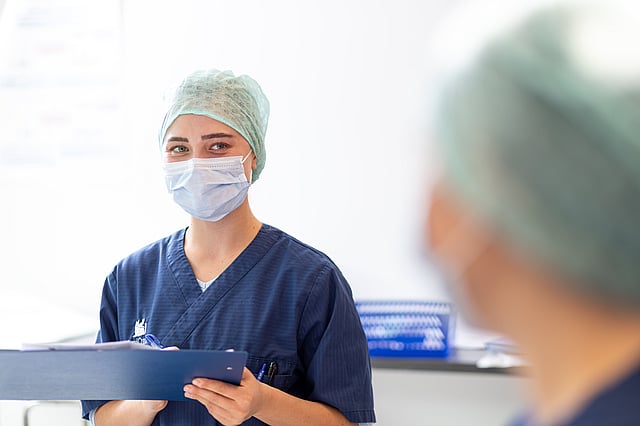 En person som bär operationskläder och mask.