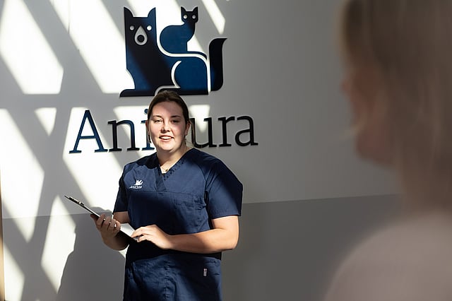 Sköterska står med ett anteckningspapper.